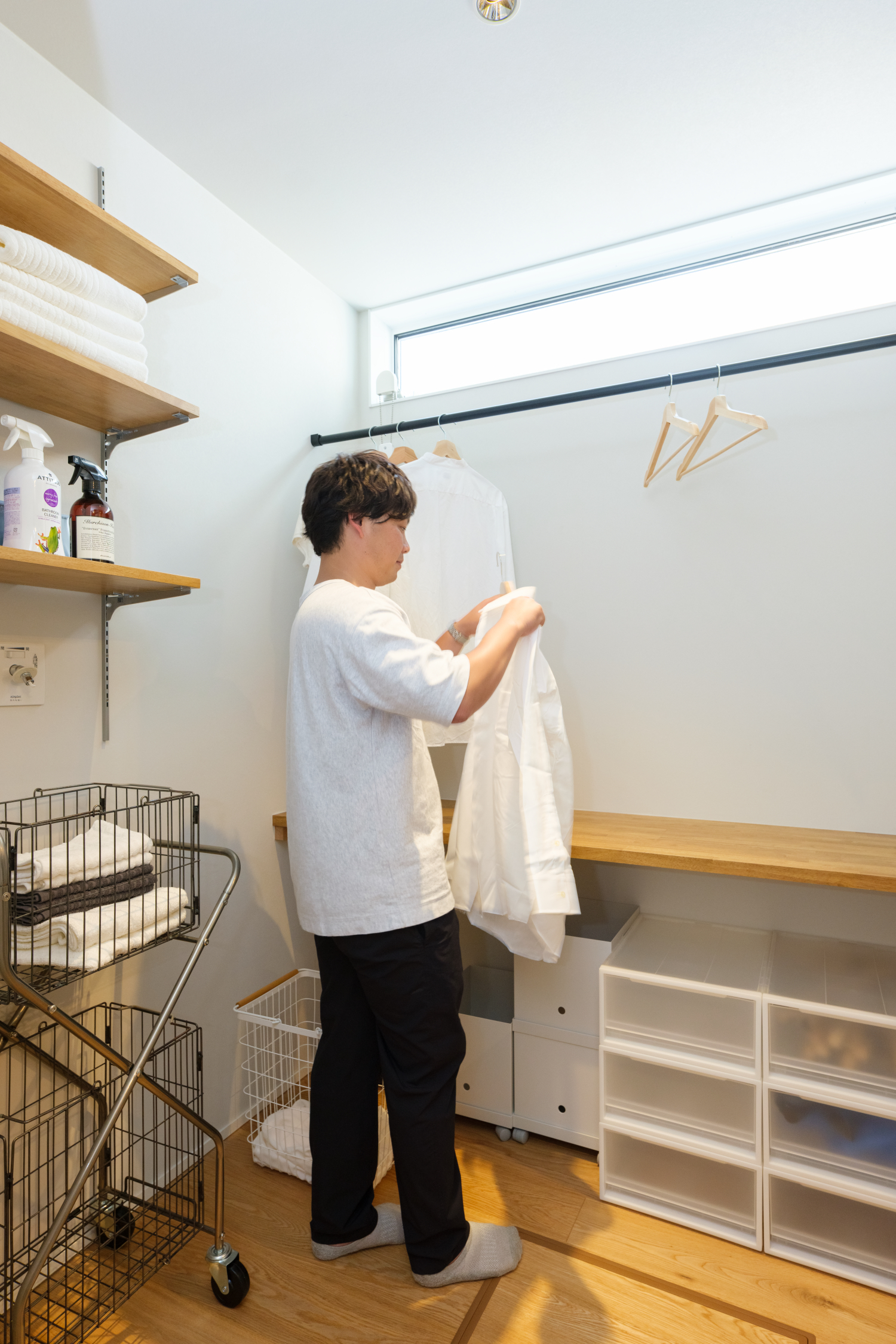室内干しの洗濯物に顔を近づけ、臭いを確かめる手元