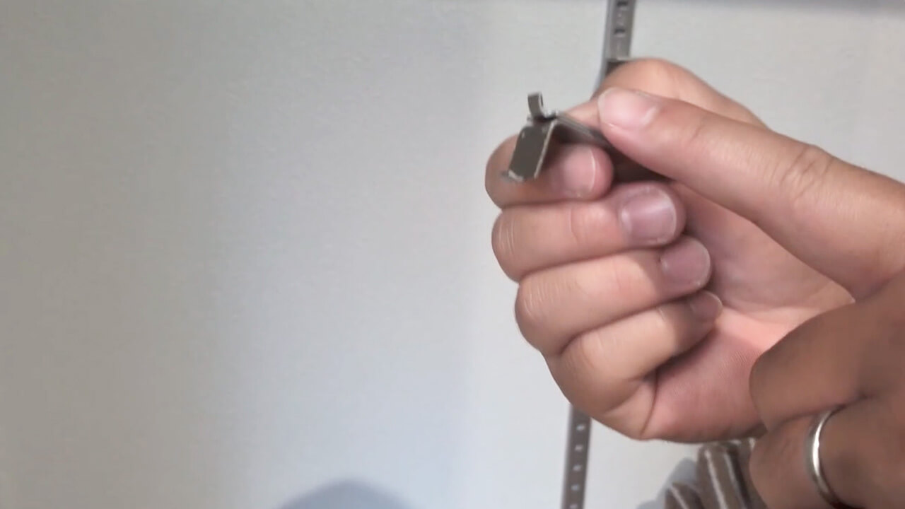 外した金具を手に持ったカット。短い側と長い側の形の違い