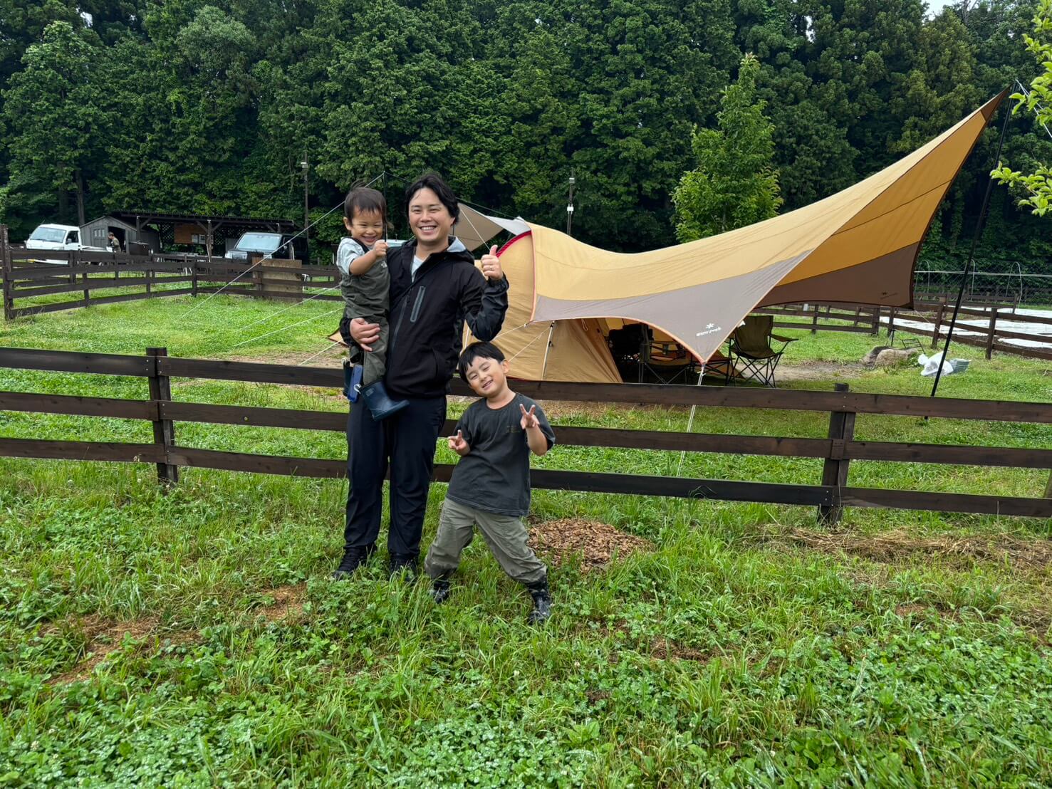 タープの前で過ごす渡部 裕貴と2人の子ども